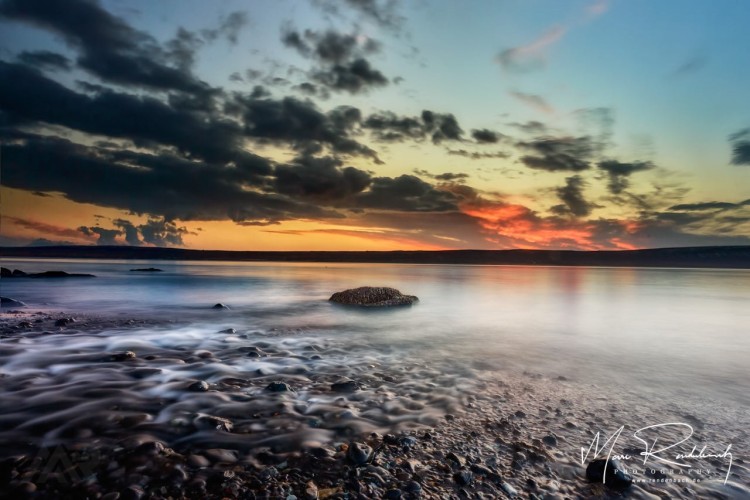 Farbenfroher Sonnenuntergang an einem einsamen Strand